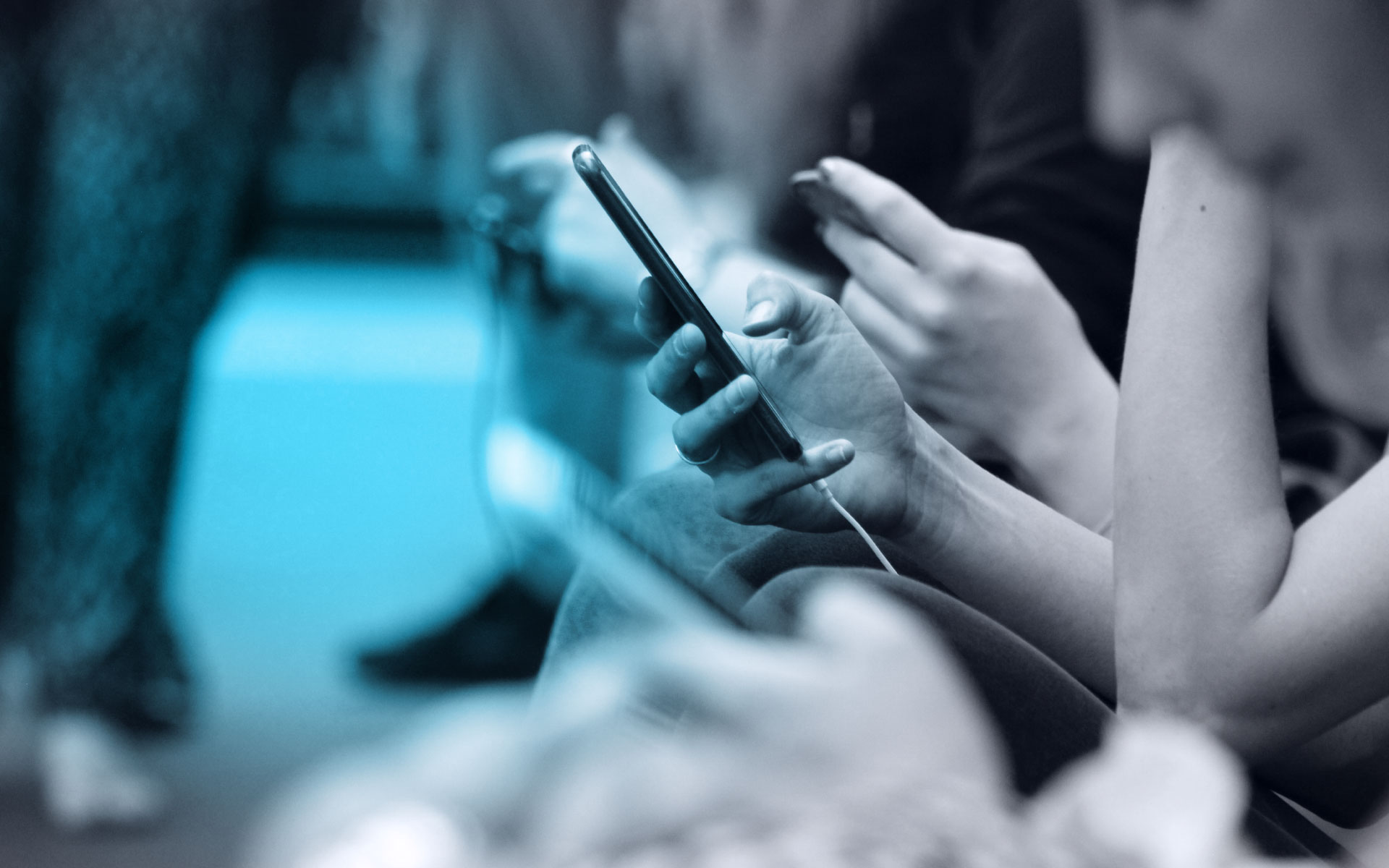 A black and white image of a person holding their phone on the subway